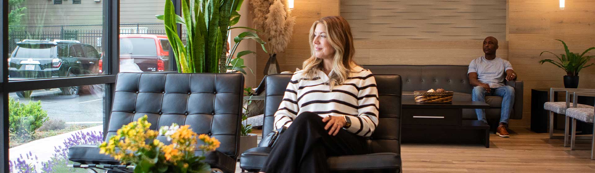 woman in waiting room smiling and staring out the window