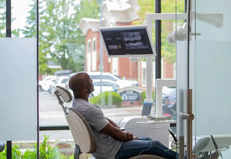 Dental patient sitting in dental chair looking at his x-rays